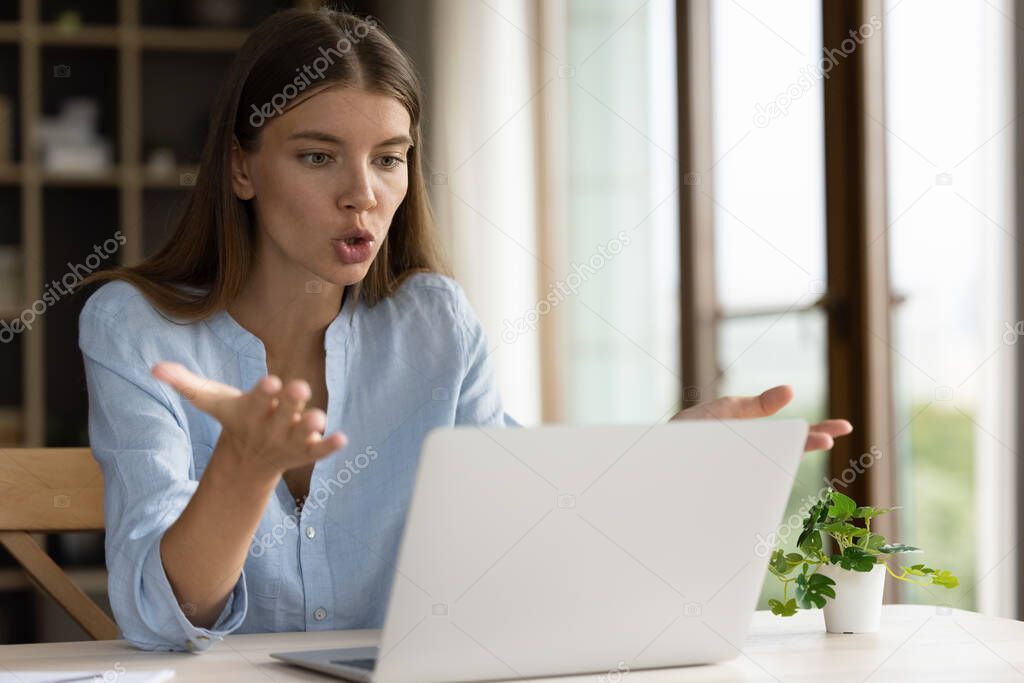 Anxious stressed millennial business woman looking at laptop screen.