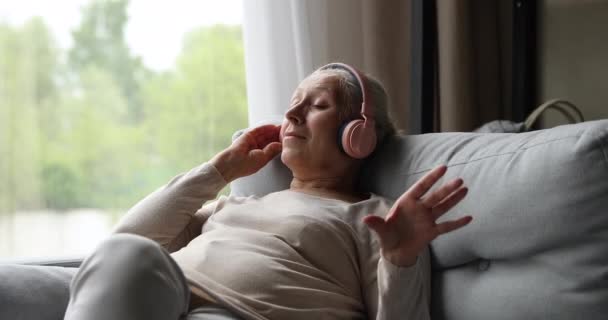 Gammal kvinna nöjd med perfekt kvalitet ljud i hörlurar — Stockvideo