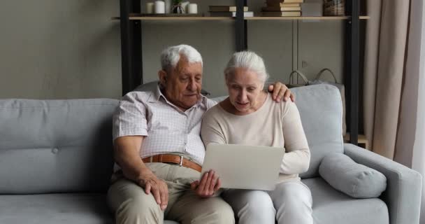 Los cónyuges mayores disfrutan del trabajo en aplicaciones web fáciles en el portátil — Vídeo de stock