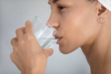 Mutlu genç melez Latin kadın su içiyor..