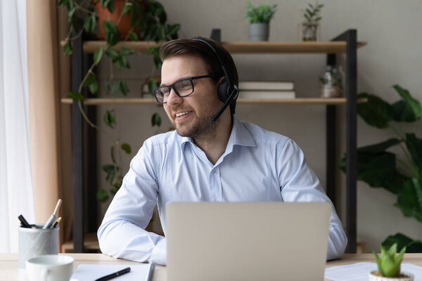 Happy dreamy young businessman holding video call meeting.