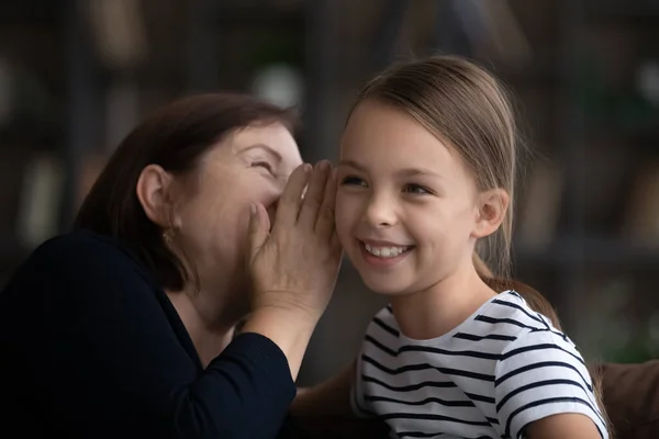Närbild lycklig mormor med lilla barnbarn skvallrar, dela hemligheter — Stockfoto