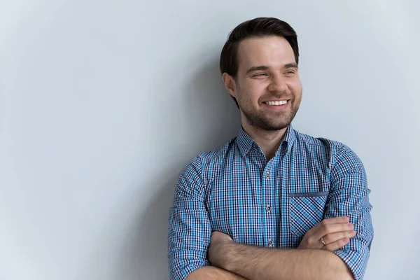 Sonriente joven mirando a distancia posando sobre fondo blanco del estudio. — Foto de Stock