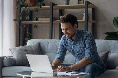 Bilgisayarda çalışan yakışıklı genç iş adamı.