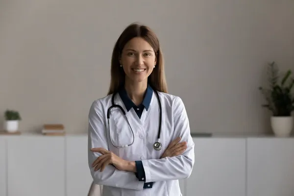 Huvudskott porträtt leende kvinnlig läkare terapeut med armarna korsade — Stockfoto