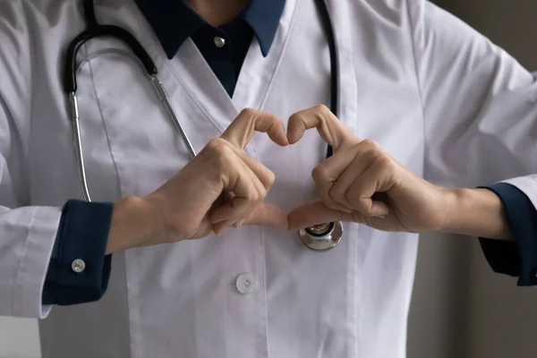 Close up cropped of female doctor cardiologist showing heart gesture — Stock Photo, Image
