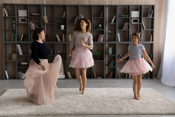 Happy tiga generasi perempuan di rok putri menari bersama-sama — Stok Foto