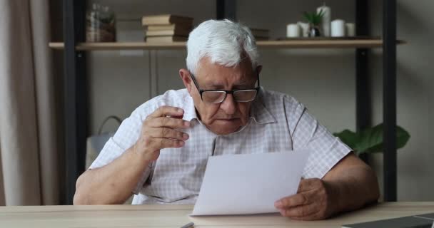 Stressed aged man troubled with bad news from paper letter — Stock Video