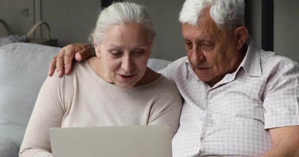 Ouderdom paar gepensioneerden leren om te werken in de computer app samen — Stockvideo