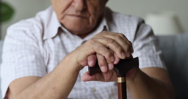 Retraité âgé mains masculines pliées sur bâton de marche — Video