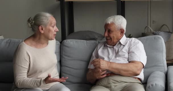Šťastní staří prarodiče se baví doma na gauči — Stock video