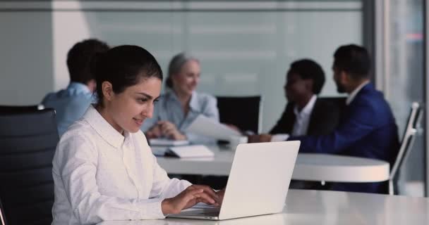 Indiska kvinna sitter på kontoret arbetar med projekt använda laptop — Stockvideo