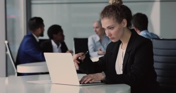 Zakenvrouw zit achter bureau met laptop, schrijven, doen sales analyse — Stockvideo