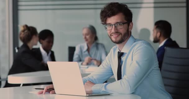 Jeune employé de bureau confiant assis au bureau avec ordinateur portable — Video