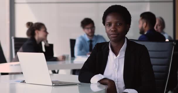 非洲成功的、自信的女商人摆姿势坐在办公室的桌子前 — 图库视频影像
