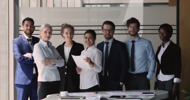 Sept équipes multinationales posant pour caméra dans un bureau moderne — Video