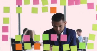 Düşünceli Hintli çalışan yapışkan notlara yazılmış bilgileri analiz eder.