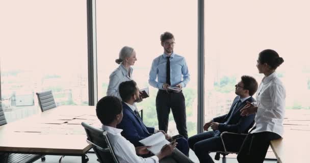 Různí zaměstnanci diskutují o agendě během ranního brífinku v kanceláři — Stock video