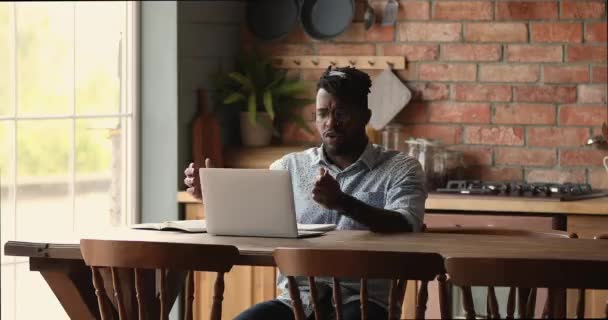 Afrykański przedsiębiorca rozmawia z klientem przez wideokonferencję na laptopie — Wideo stockowe