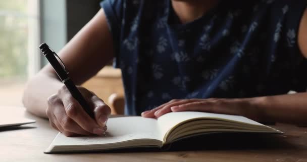 Closeup woman sit at table writing in personal diary — Stock Video