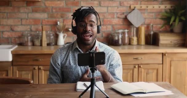 Kulaklıklı Afrikalı adam akıllı telefon kamerasıyla konuşuyor. — Stok video