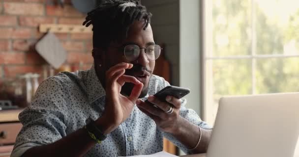 Afrikaanse man houdt smartphone praten met vriend met behulp van speakerphone — Stockvideo