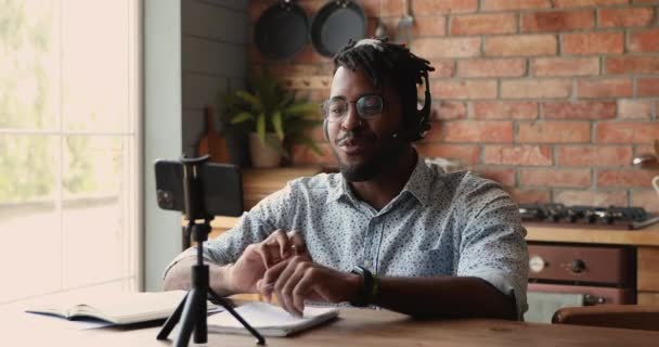 Afrikansk man bloggare bära headset rekord nya vlog på smartphone — Stockvideo