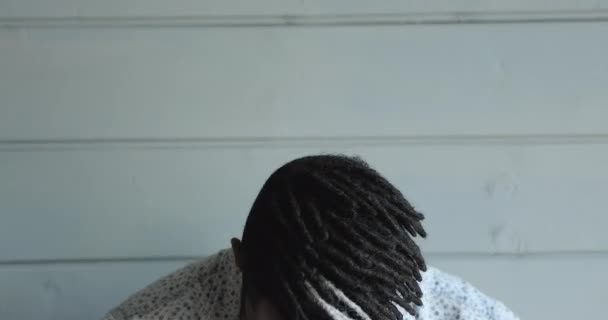 Primer plano africano hipster chico mira a la cámara riendo — Vídeos de Stock