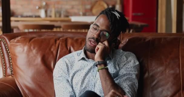 Afričan sedí na pohovce vést osobní rozhovor na telefonu — Stock video