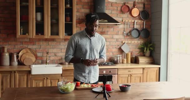 Africano homem de pé em registros de cozinha em videoblog comida celular — Vídeo de Stock