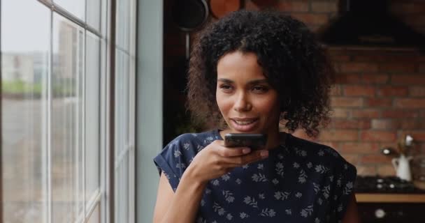 Mujer africana sosteniendo el teléfono móvil hace llamada usando altavoz — Vídeos de Stock