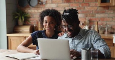 Bilgisayarı kullanan Afrikalı çift internette alışverişi tartışıyor