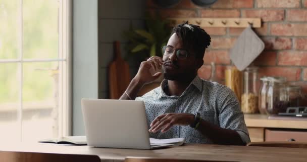 El hombre africano reflexivo que estudia el aprendizaje en línea utiliza el ordenador portátil — Vídeo de stock