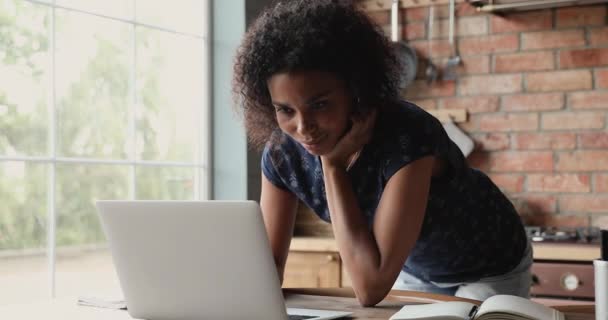 Afrikaanse vrouw kijkt naar laptop leren nieuwe software of toepassing — Stockvideo