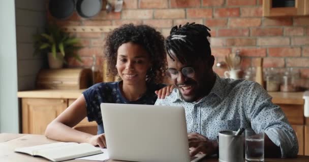 Африканская пара с помощью ноутбука обсудить покупку в Интернете — стоковое видео