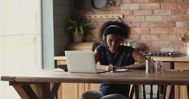 Mulher africana em fones de ouvido estudando uso de tecnologia moderna e internet — Vídeo de Stock