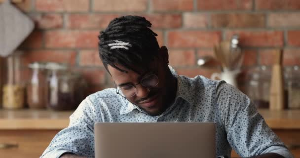 Африканський чоловік дивиться вебінар робить нотатки з електронного навчання вдома — стокове відео