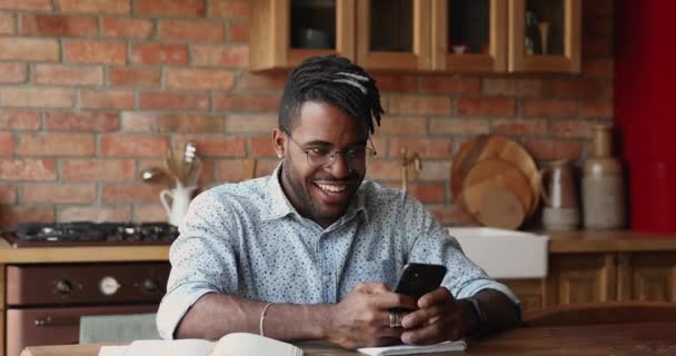 Afričan drží mobilní telefon čtení zprávy vypadá velmi šťastný — Stock video