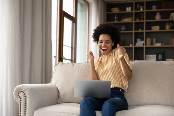 Eccitato allegra giovane donna nera utilizzando computer portatile — Foto Stock