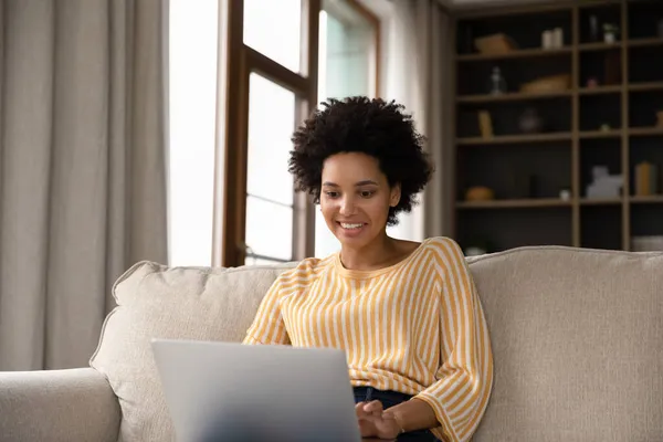 Feliz millennial chica negra comprometida en el uso de ordenador portátil — Foto de Stock