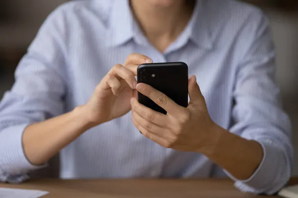 Закрыть женские руки, держа смартфон, используя новое мобильное приложение — стоковое фото