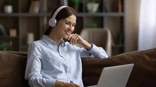 Vrouw in hoofdtelefoon gebruik laptop horloge film of onderwijs webinar — Stockfoto