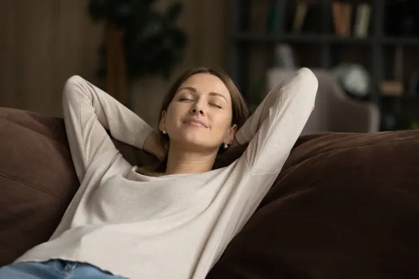 Drömmande kvinna somnar på soffan hemma — Stockfoto