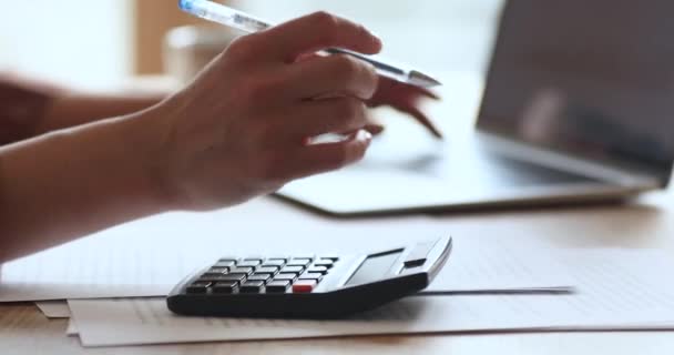 Vrouwelijke accountant doet elektronisch papierwerk met behulp van papieren documenten laptop calculator — Stockvideo