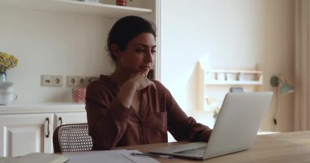 Pensiva donna indiana millenaria lavora in internet su pc portatile — Video Stock
