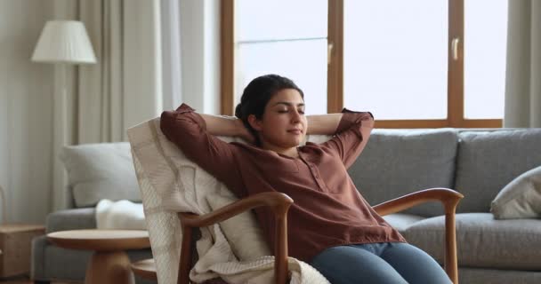 Serene jonge Indiase vrouw leunen in stoel met gesloten ogen — Stockvideo