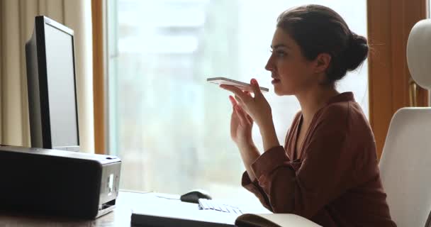 Молодая индийская бизнесвумен работает с помощью компьютера, отправляя электронные письма по сотовому телефону — стоковое видео