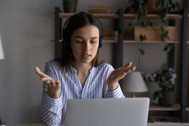 Kulaklıklı genç bir kadın video görüşmesi yapıyor..