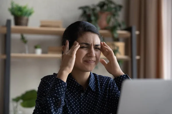 Stressed young Indian businesswoman suffering from headache. — Stock Photo, Image