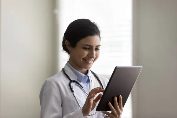 Hlava záběr usmívající se mladá indická žena lékař pomocí tablet — Stock fotografie